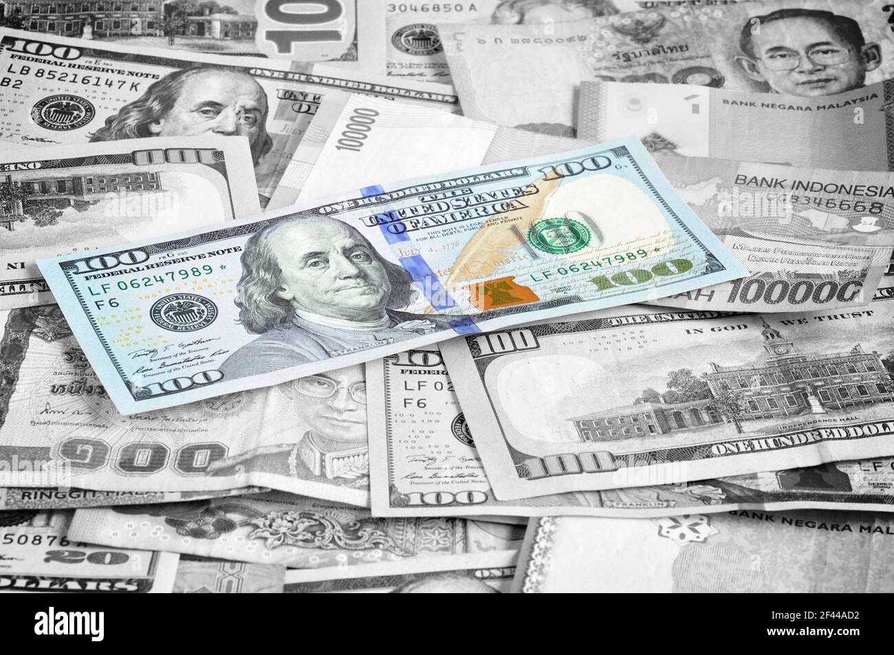 Denaro in più valute con un conto di 100 USD in cima Foto Stock