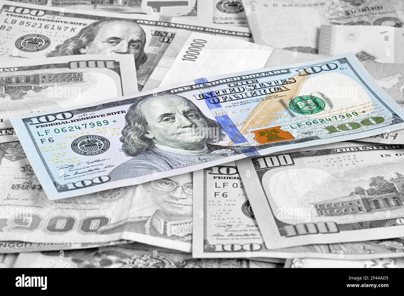 Denaro in più valute con un conto di 100 USD in cima Foto Stock