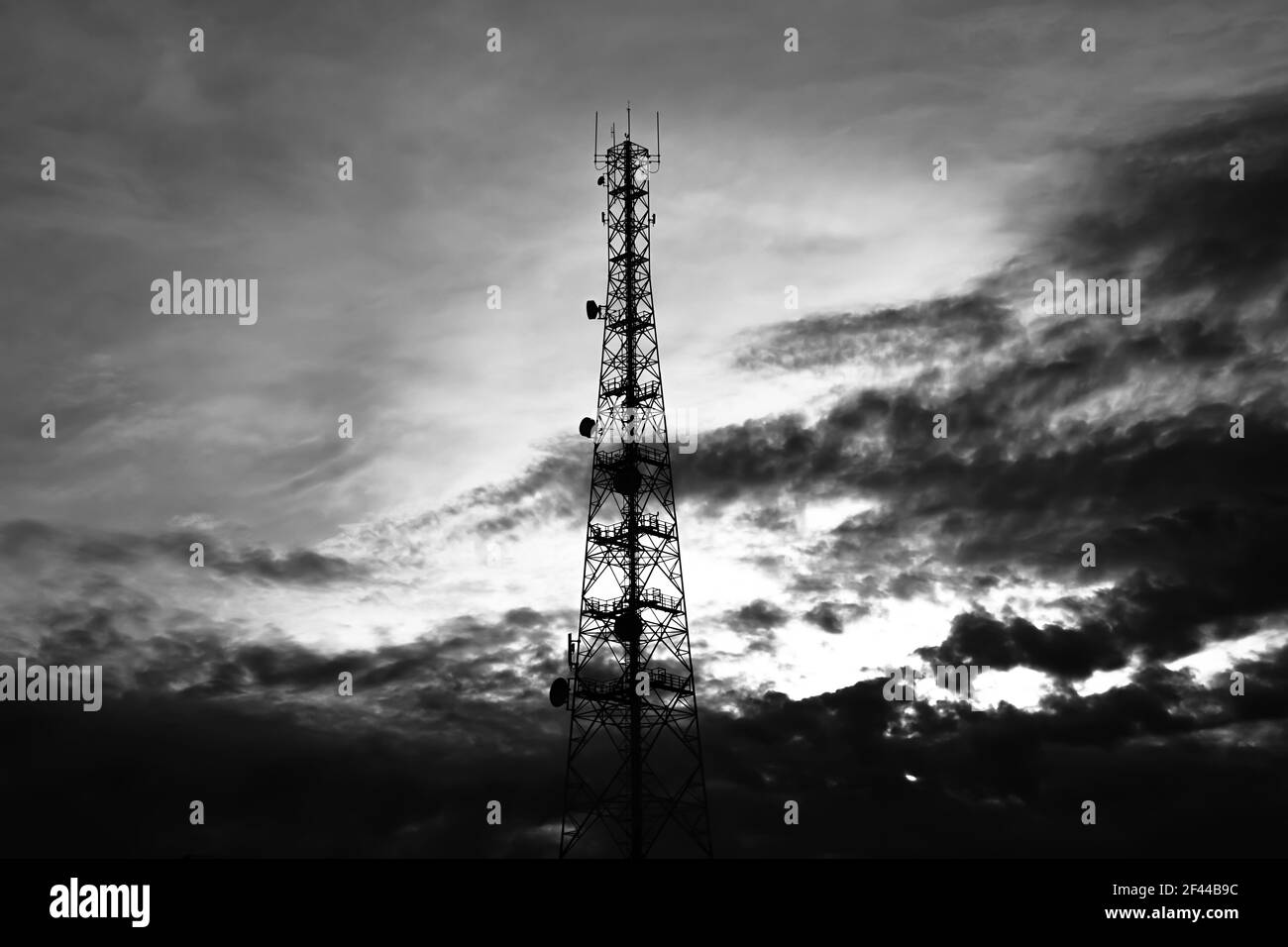 Telecom torre su cielo e nuvole sfondo - effetto monocromatico Foto Stock
