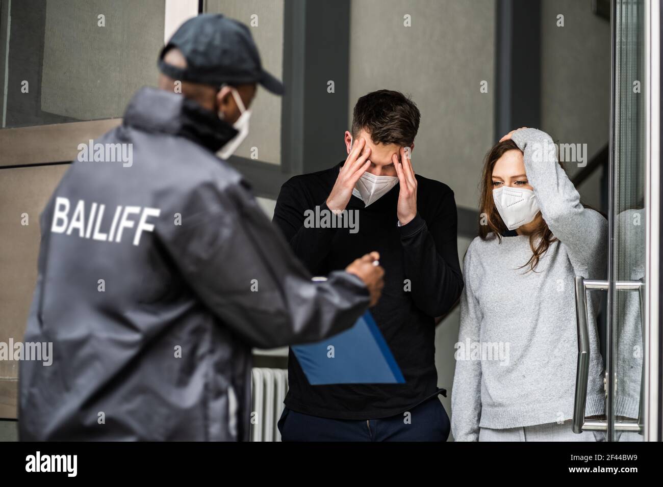 Bailiff debt Collector a Door in Mask Foto Stock