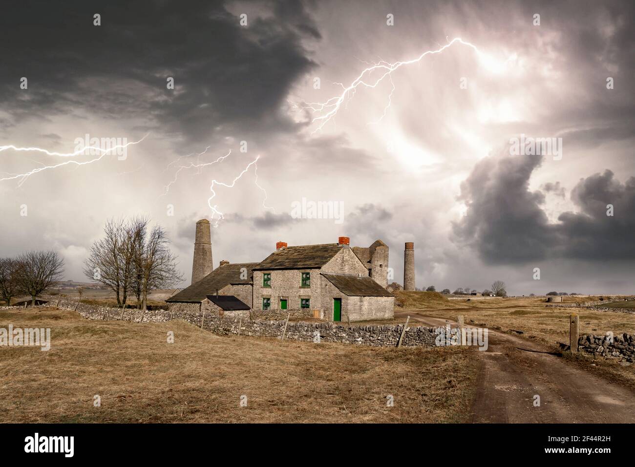 Abbandonato casetta di pietra rurale vuoto nel Distretto di picco vicino a. vecchie miniere deserte antiche che si stanno facendo con drammatiche tempeste di fulmini bulloni sospesi sky Foto Stock