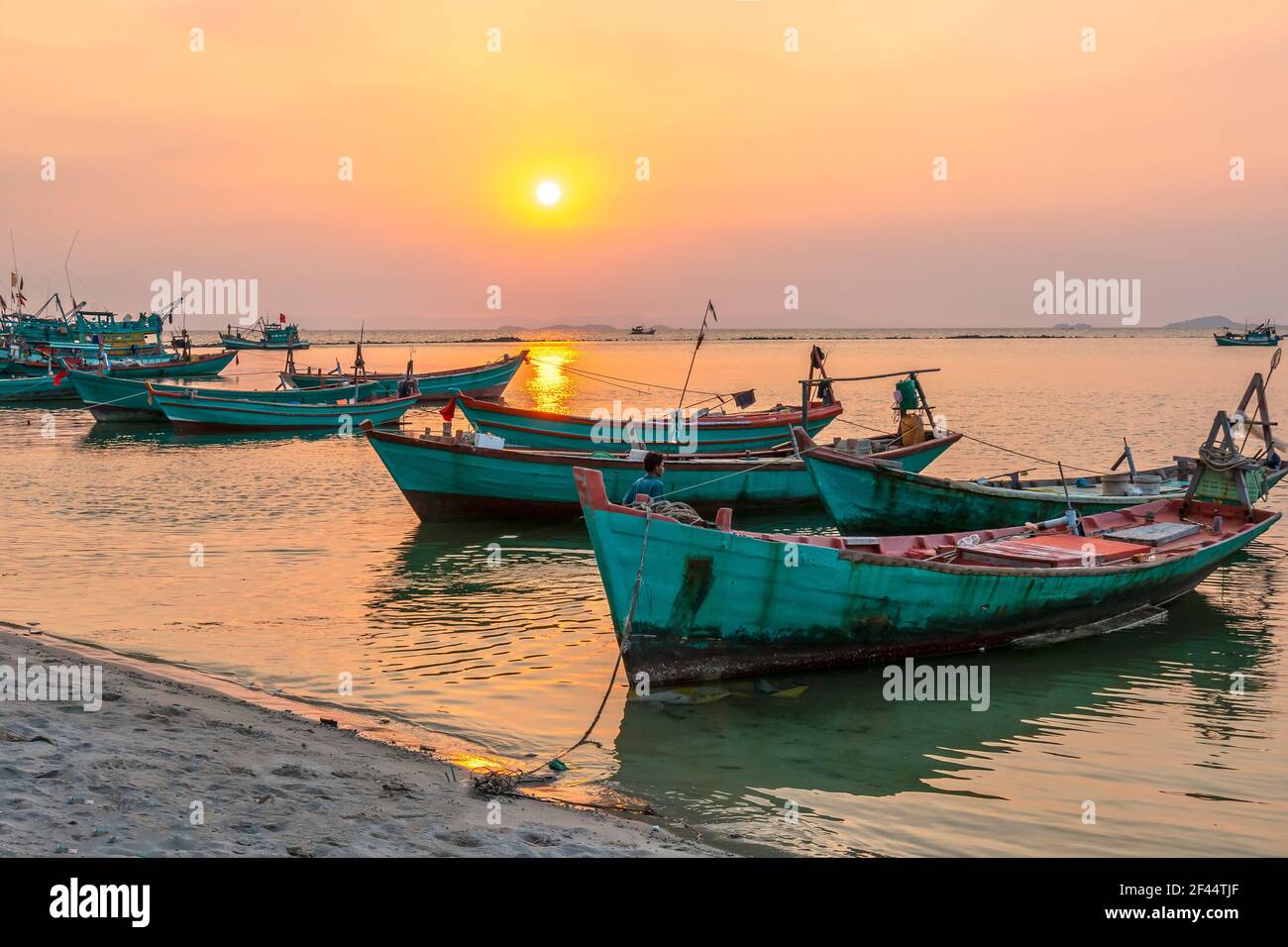 Il tramonto sulla splendida baia quando la barca da pesca si affaccia sul sole è anche la fine della giornata a ha Tien, Vietnam Foto Stock