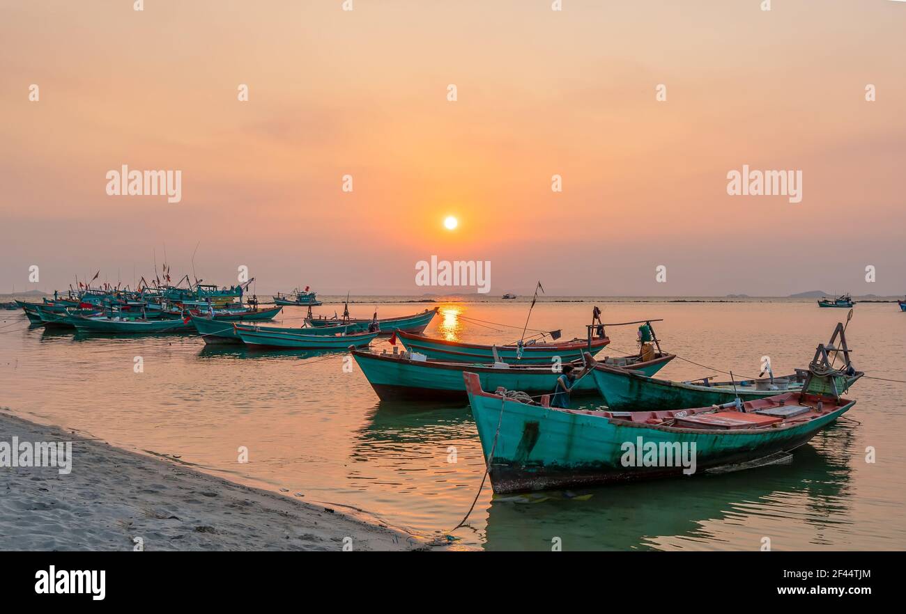Il tramonto sulla splendida baia quando la barca da pesca si affaccia sul sole è anche la fine della giornata a ha Tien, Vietnam Foto Stock