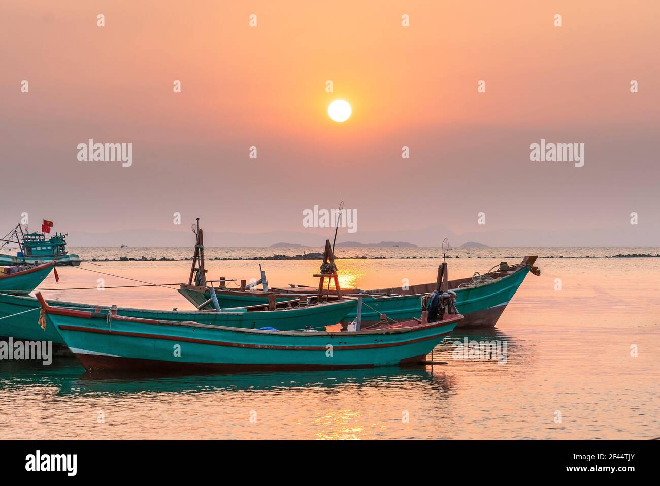 Il tramonto sulla splendida baia quando la barca da pesca si affaccia sul sole è anche la fine della giornata a ha Tien, Vietnam Foto Stock