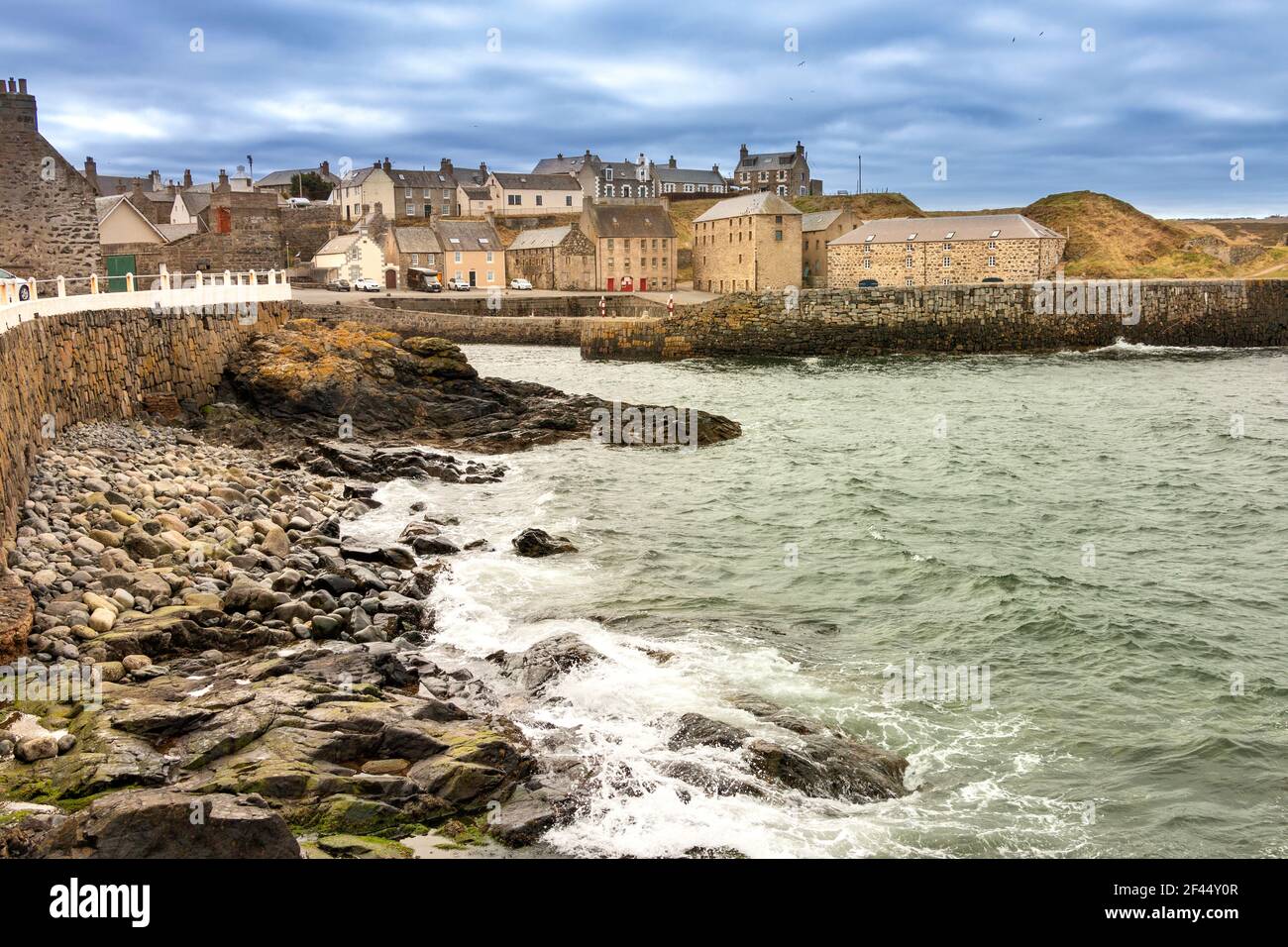 PORTSOY OLD HARBOR MORAY FIRTH ABERDEENSHIRE SCOTLAND WAVES BREAKING ON IL MURO DEL PORTO Foto Stock