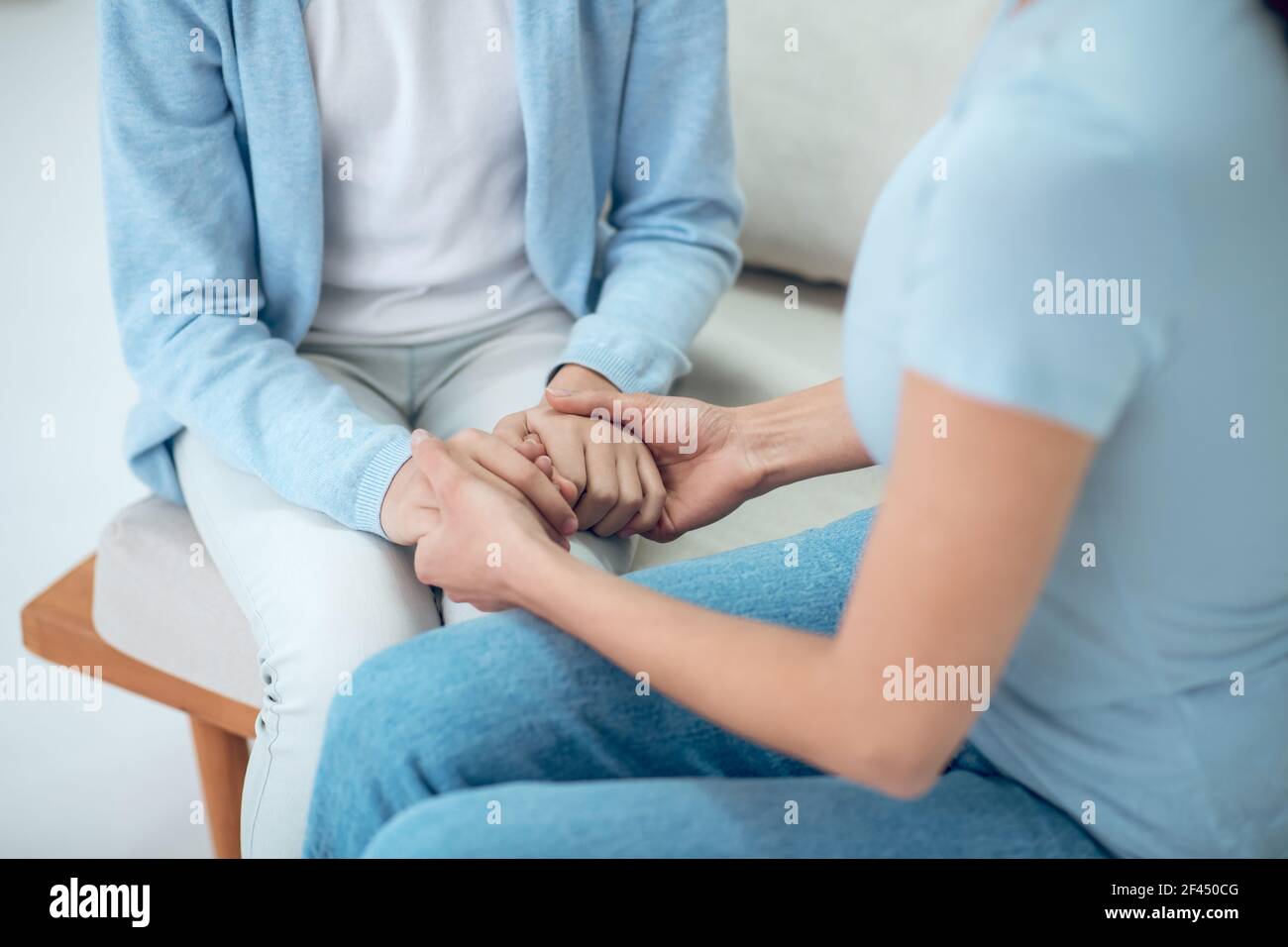 Le figlie mani in madri teneri e amorevoli Foto Stock