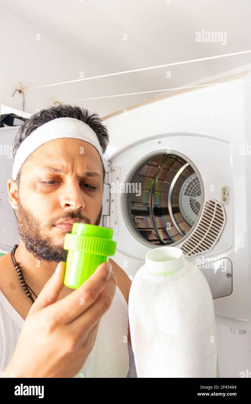 Giovane uomo con archetto che va lavare la vostra lavanderia sporca Foto Stock