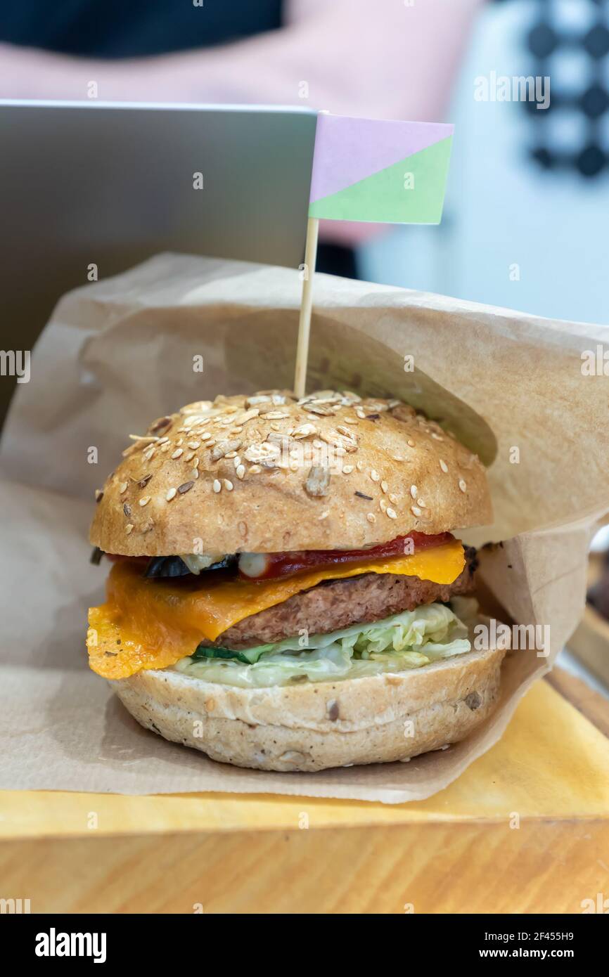Hamburger di fagioli vegano fatto in casa con polpettine di hamburger alla griglia a base di piante, formaggio di soia e salsa su scrivania di legno. Foto Stock