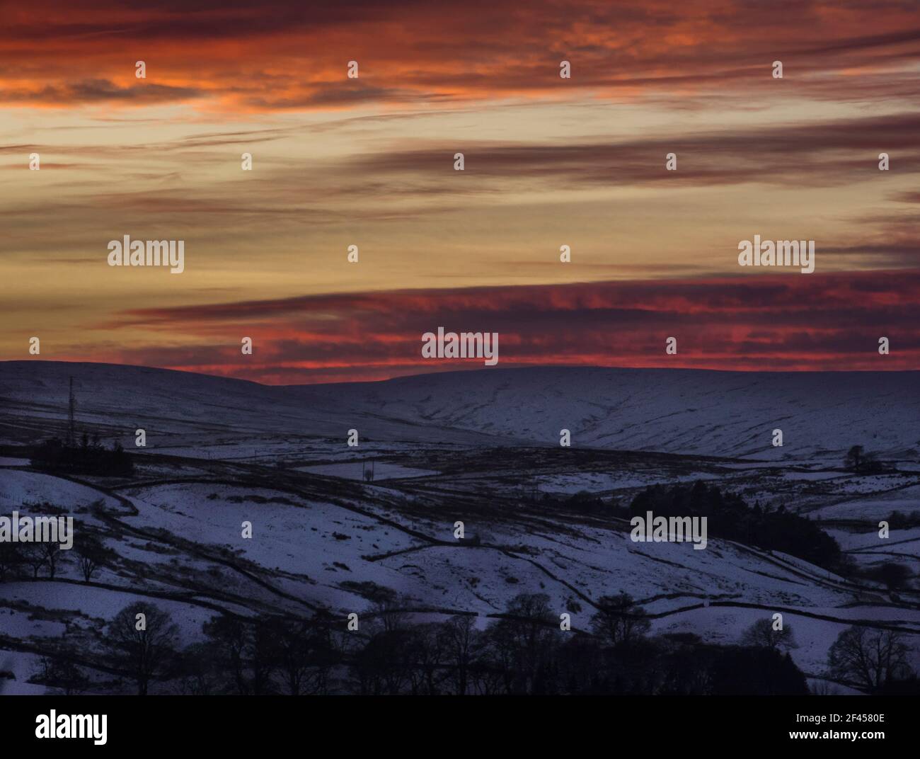 Tramonto spettacolare e mozzafiato sulle colline innevate e sulle montagne e sull'albero TV di Ireshopeburn (Weardale, The North Pennines, County Durham, Regno Unito) Foto Stock