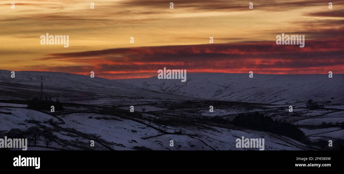 Tramonto spettacolare e mozzafiato sulle colline innevate e sulle montagne e sull'albero TV di Ireshopeburn (Weardale, The North Pennines, County Durham, Regno Unito) Foto Stock