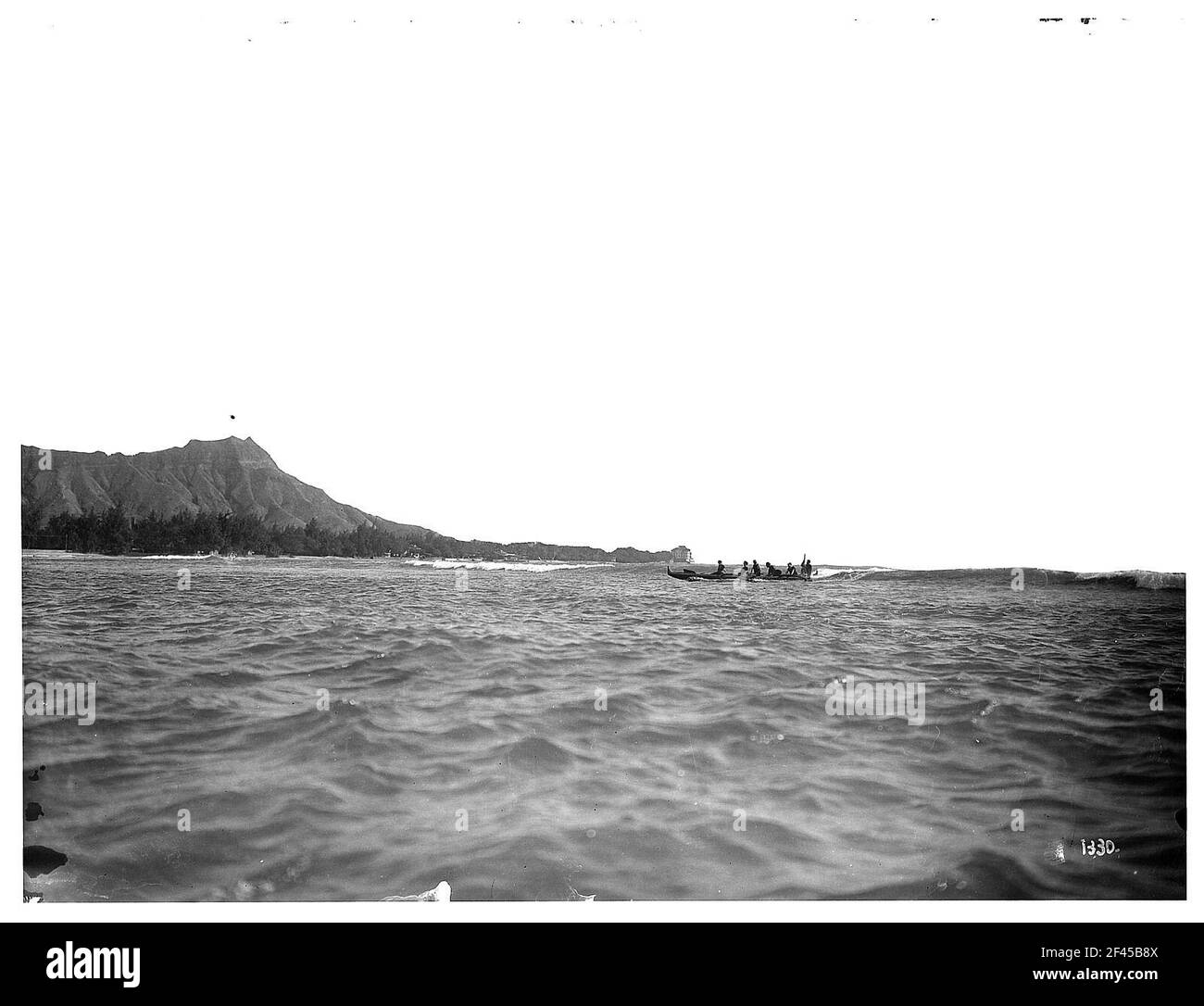 Honolulu-Waikiki. Cinque uomini in una barca nel surf sull'Oceano Pacifico (a sinistra: Diamond Head (232 m)) Foto Stock