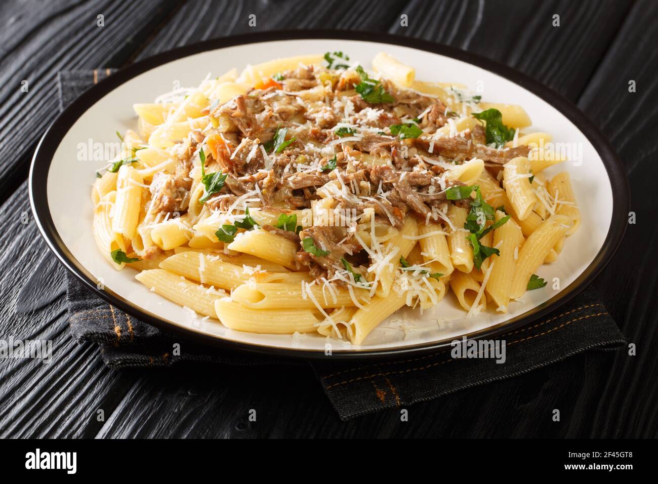 La genovese la salsa di carne e cipolla di Napoli e la pasta di penne primo piano su un piatto sul tavolo. Orizzontale Foto Stock