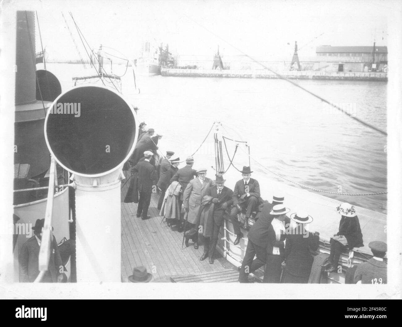 Crociere della linea Hamburg America, circa 1911/1913. Turisti su un vaporizzatore all'arrivo in un porto. Sullo sfondo molo con gru a nave e battello a vapore paesaggistico Foto Stock