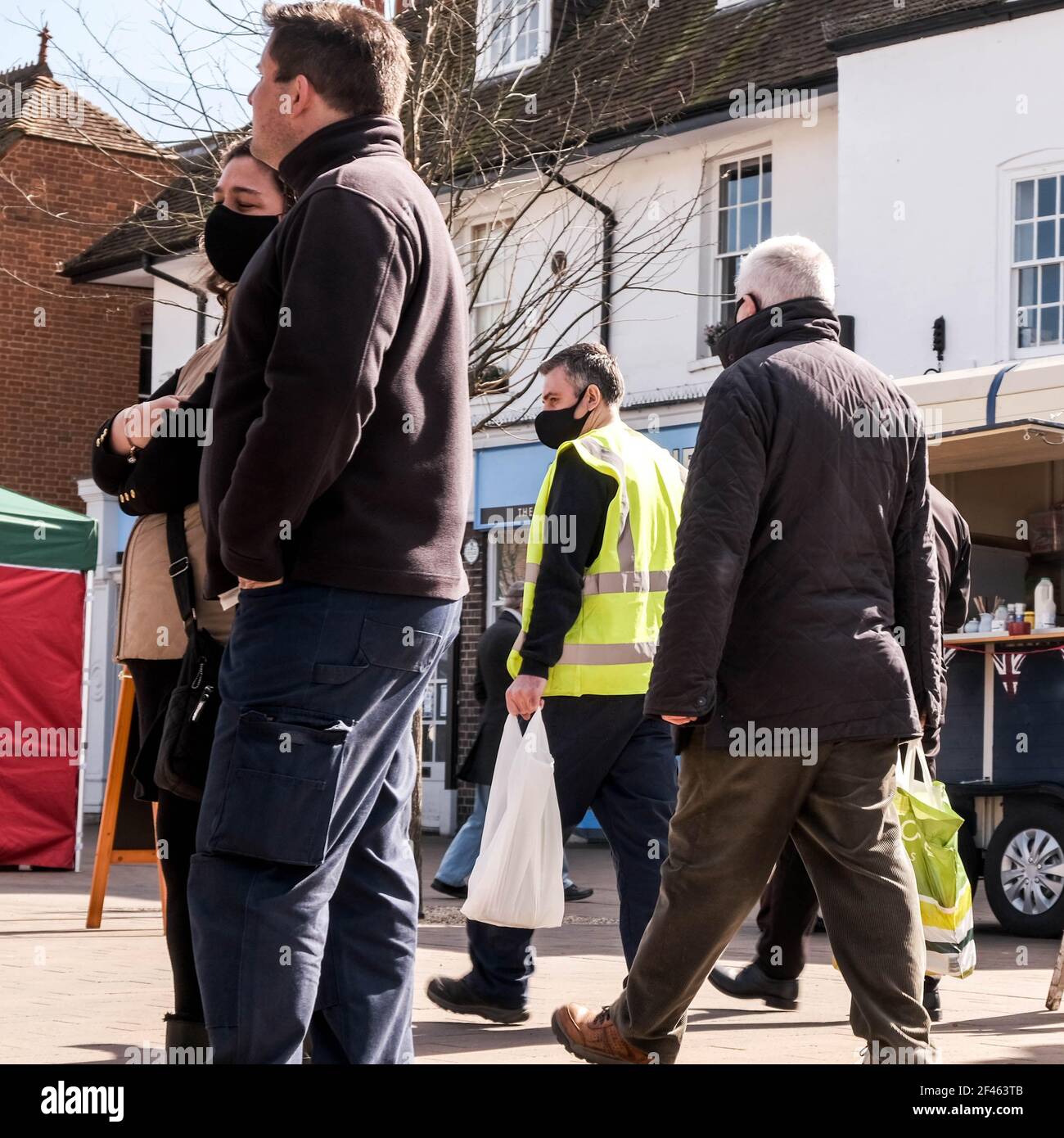 Londra UK, marzo 19 2021, gli acquirenti si svegliano all'esterno indossando rivestimenti protettivi per il viso o maschere Foto Stock