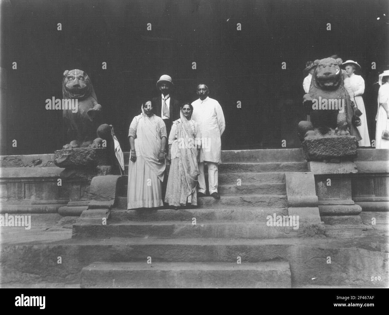 Elefanta, India. Shiva tempio di grotte di roccia. Una delle entrate con locali e turisti di Hapag sulla scala aperta con sculture di leoni fiancheggianti Foto Stock