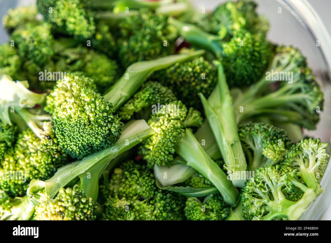Una ciotola di vetro di broccoli grezzi Foto Stock