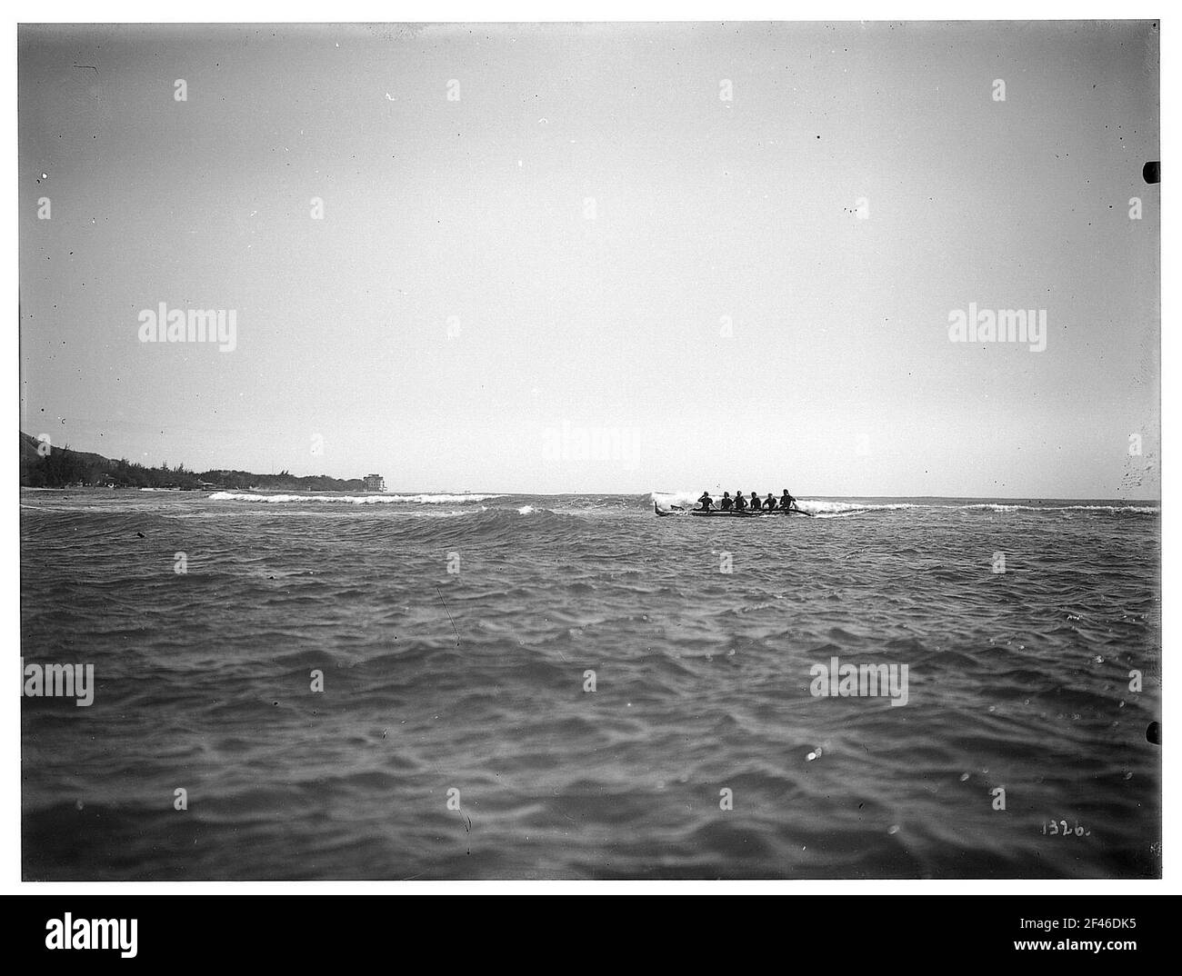 Honolulu-Waikiki. Cinque uomini in una barca nel surf sull'Oceano Pacifico Foto Stock
