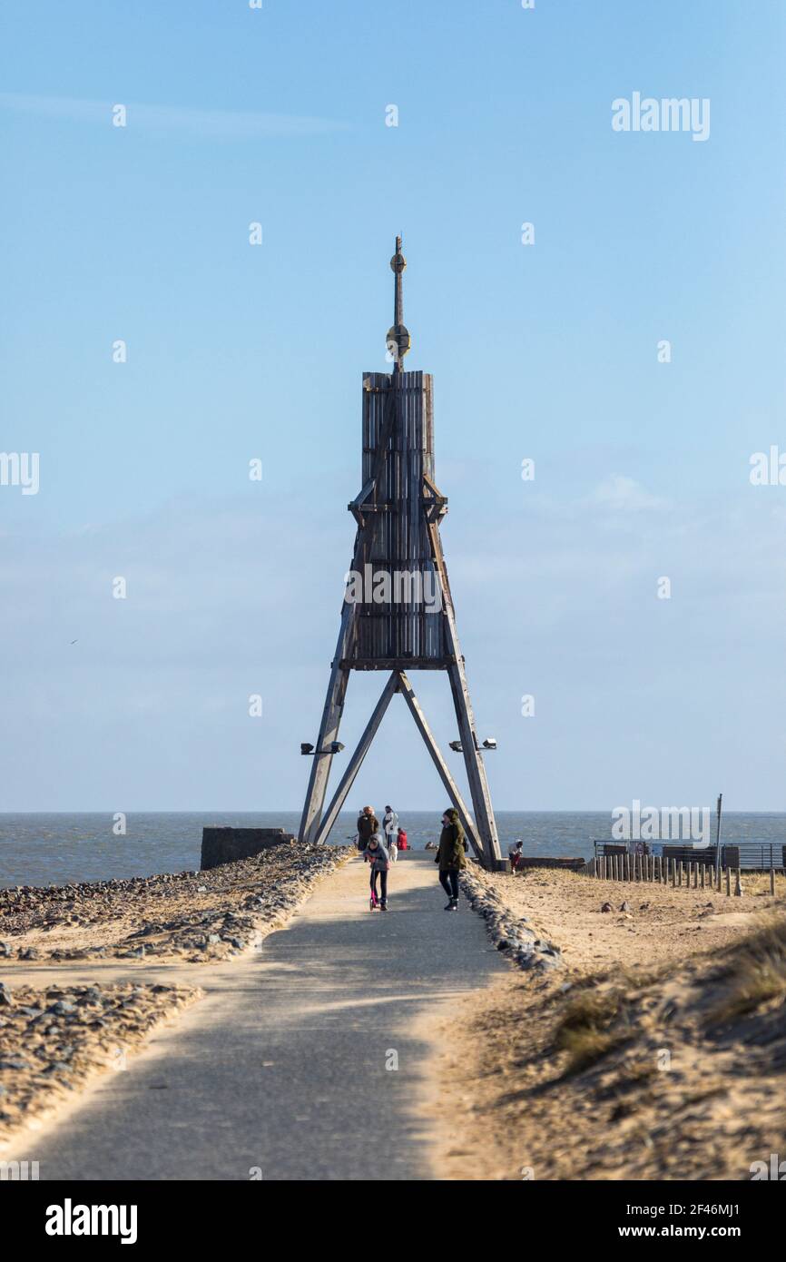 Escursionisti di un giorno visitando il faro di Kugelbake, simbolo della città sull'estuario del fiume Elba. Vista lungo il sentiero dei piedi sul frangiflutti Foto Stock