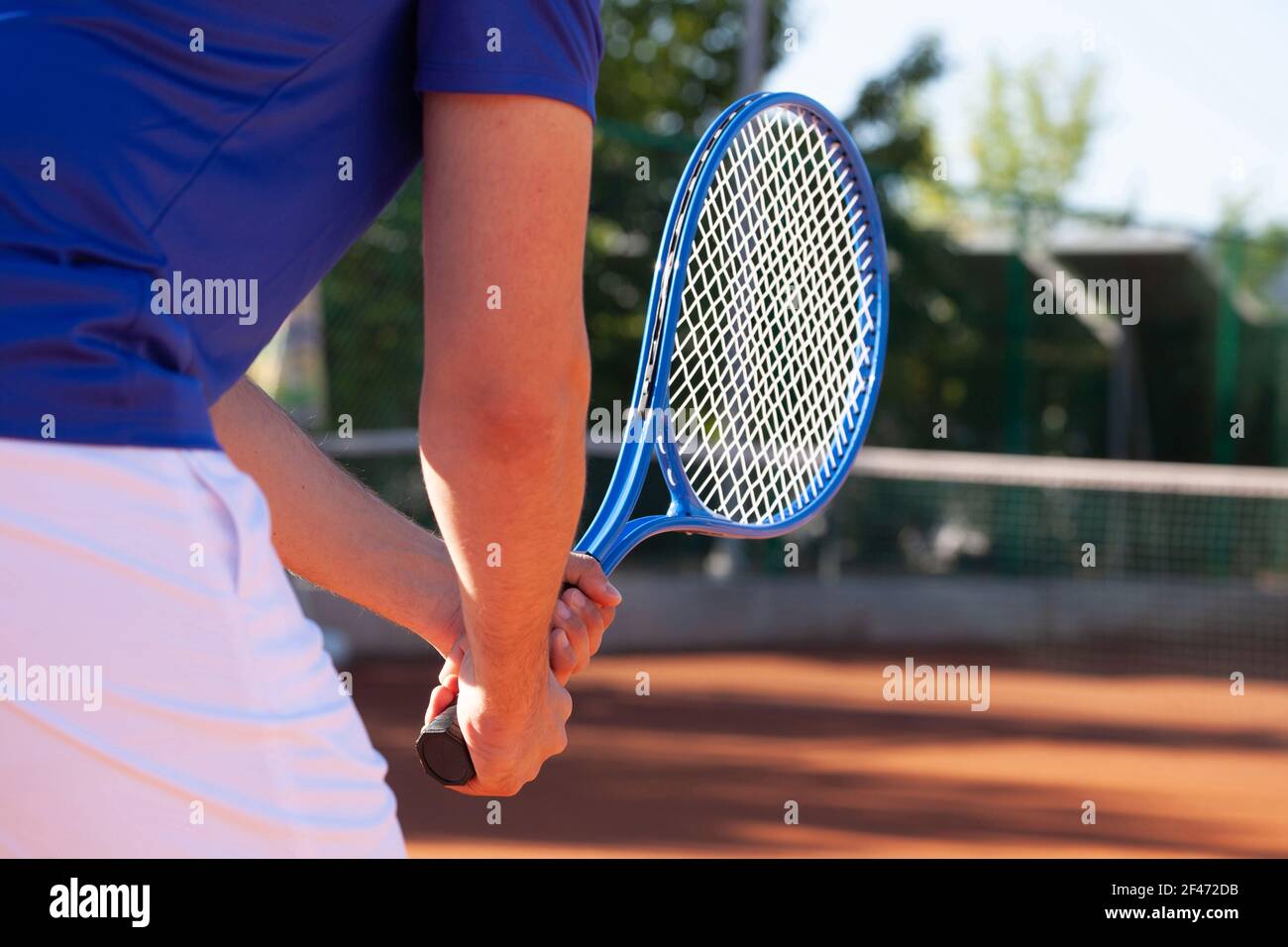 Tennista professionista che tiene una racchetta da tennis in due mani in attesa del servizio dell'avversario Foto Stock