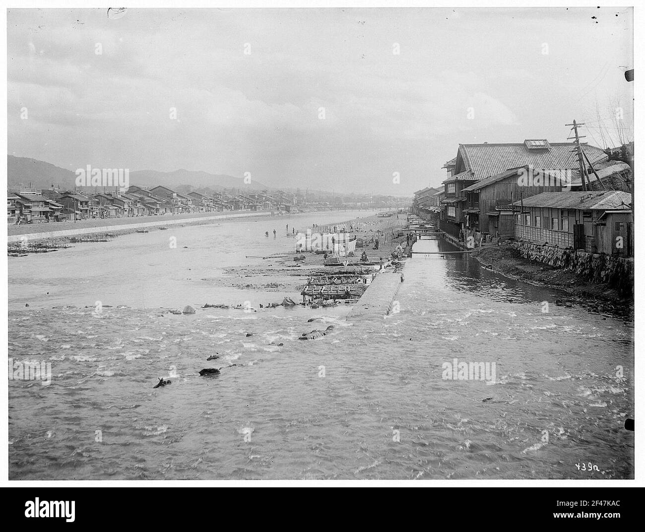 Nara. Semplici edifici residenziali (capanne) della gente del posto su entrambi i lati del fiume Foto Stock