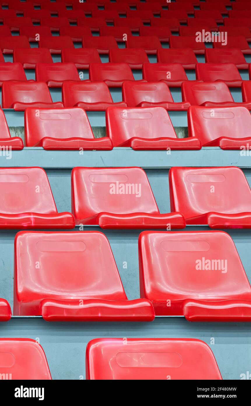 Sedili in plastica rossa numerati per lo stadio - vista verticale Foto Stock