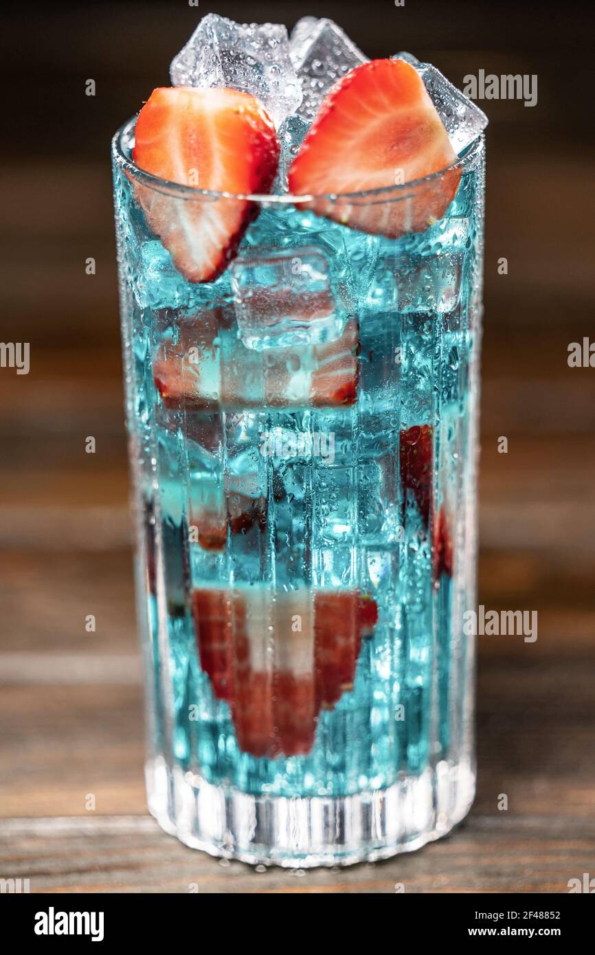 Cocktail blu con ghiaccio e fragole. Primo piano. Messa a fuoco selettiva Foto Stock