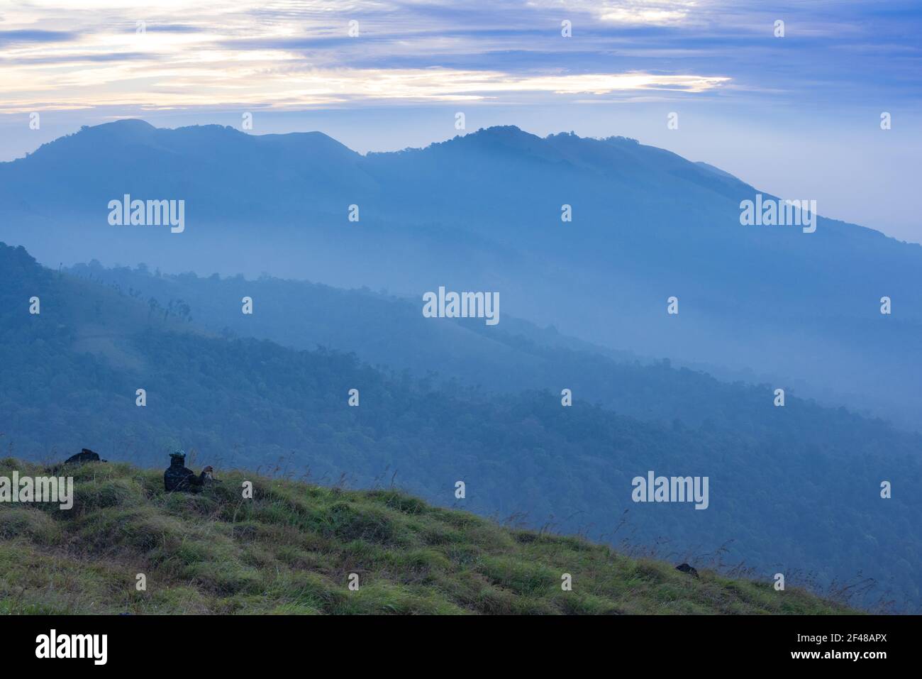 Una signora che gode della magnifica vista da una collina a Wayanad durante la mattina presto (immagine presa a Wayanad, Kerala) Foto Stock