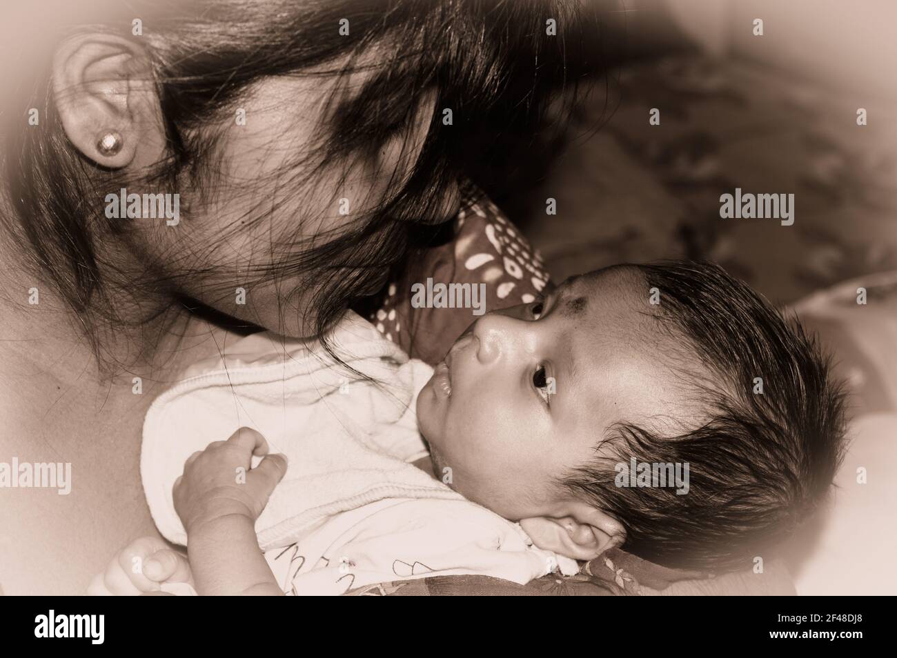 Adorabile mamma e lulling neonato figlio. Ritratto amorevole di mamma felice abbracciando bambino infante sulle mani. Giovane madre e bambino attaccme emotivo Foto Stock