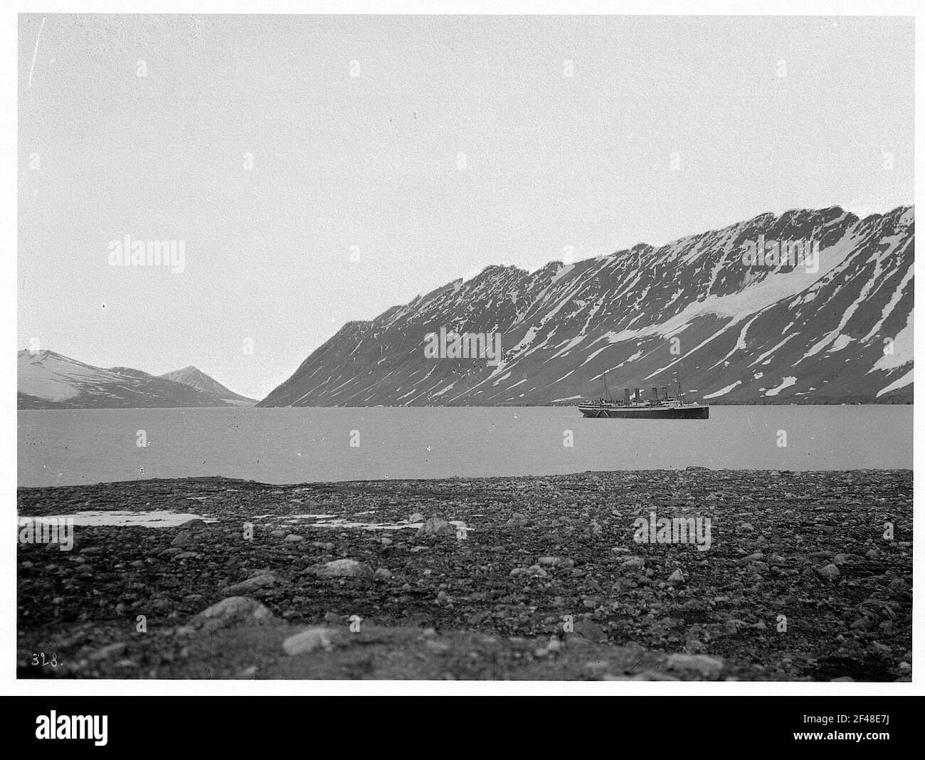 Spitzbergen, Norvegia. Crossbay. Passeggero in alto mare Stupper 'Victoria Luise' di fronte alle montagne innevate nel Kreutzbucht da terra Foto Stock