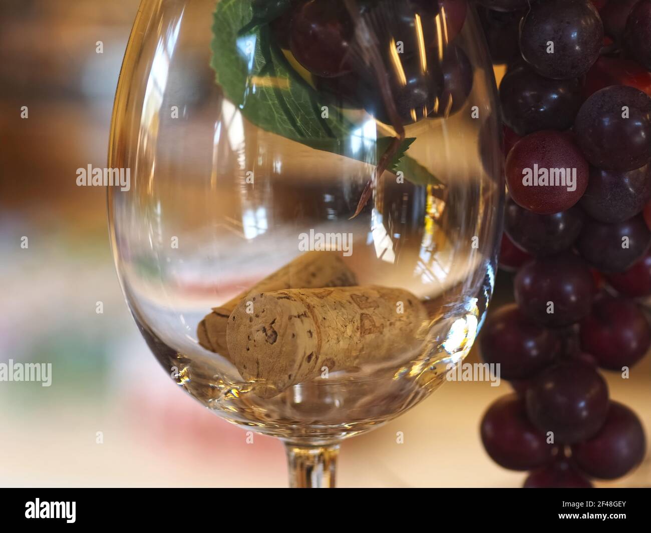 Bicchiere con tappi di vino e uva rossa Foto Stock