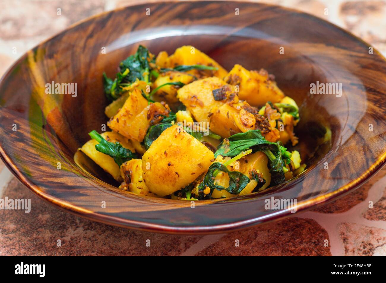 Aloo indiano saag, patate e verdure al curry piatto Foto Stock