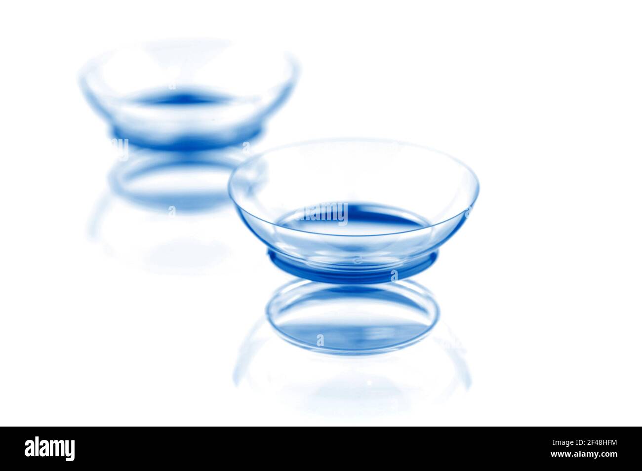 Due lenti a contatto con riflessi, isolate su sfondo bianco Foto Stock
