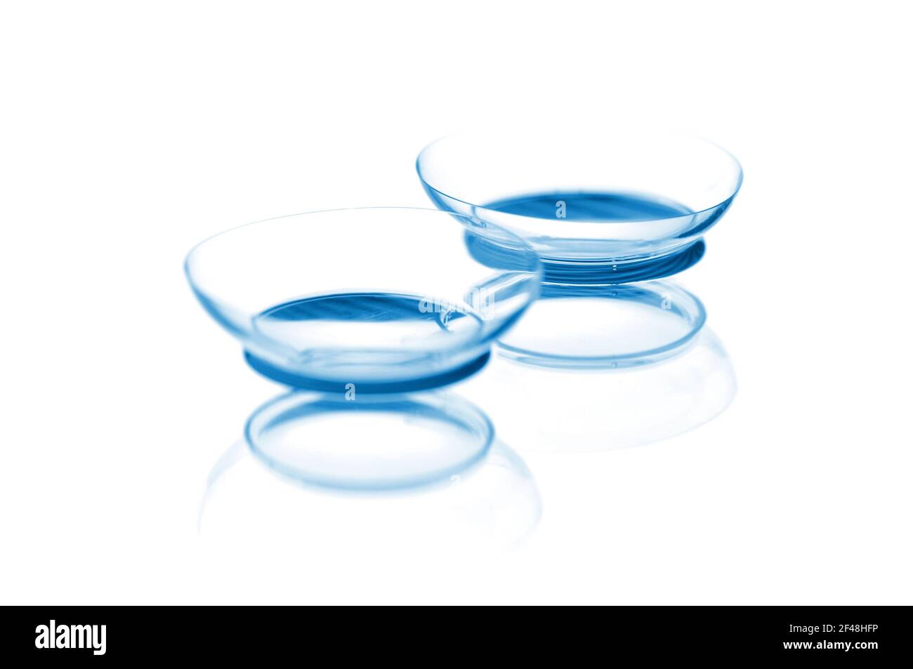 Due lenti a contatto con riflessi, isolate su sfondo bianco. Messa a fuoco su obiettivi a lunga distanza. Foto Stock
