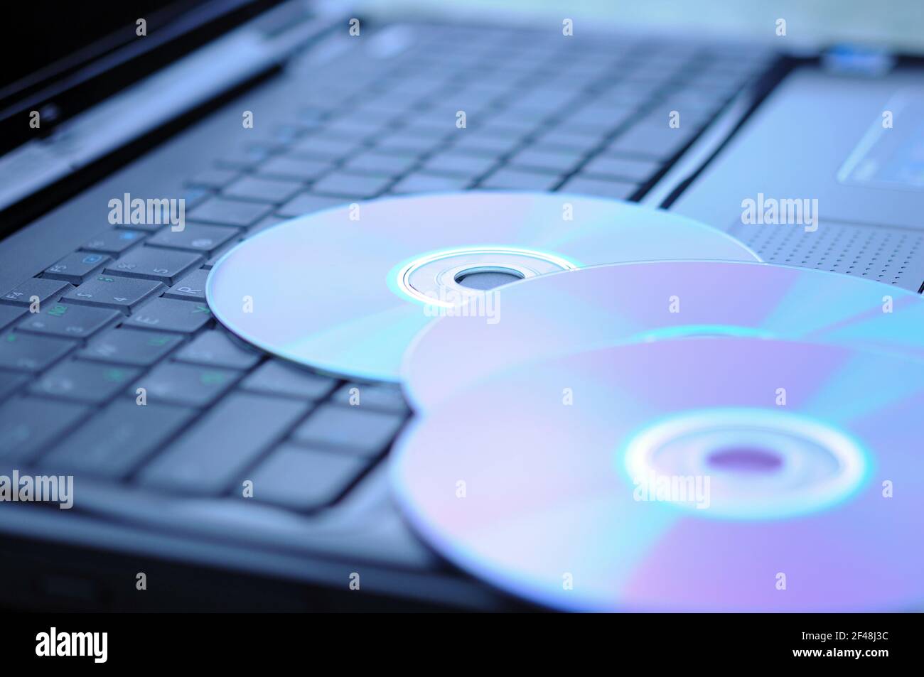 Tre dischi DVD sulla tastiera di un computer portatile. Foto Stock