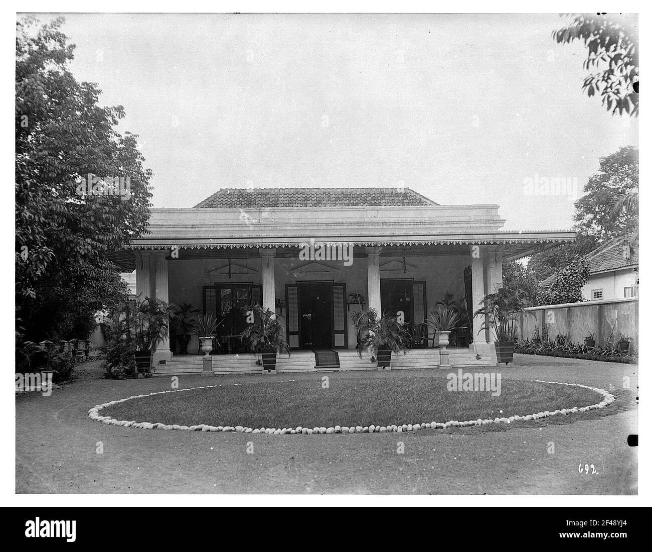 Buitenzorg (oggi Bogor), Java, Indonesia. Casa privata a un piano. Vista sul fronte su un prato rondel Foto Stock
