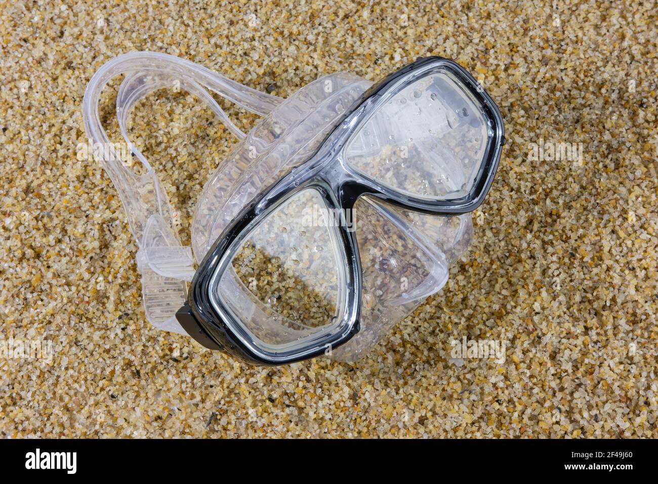 Maschera subacquea bagnata su una spiaggia di sabbia. Sport estivi e tempo libero. Foto Stock