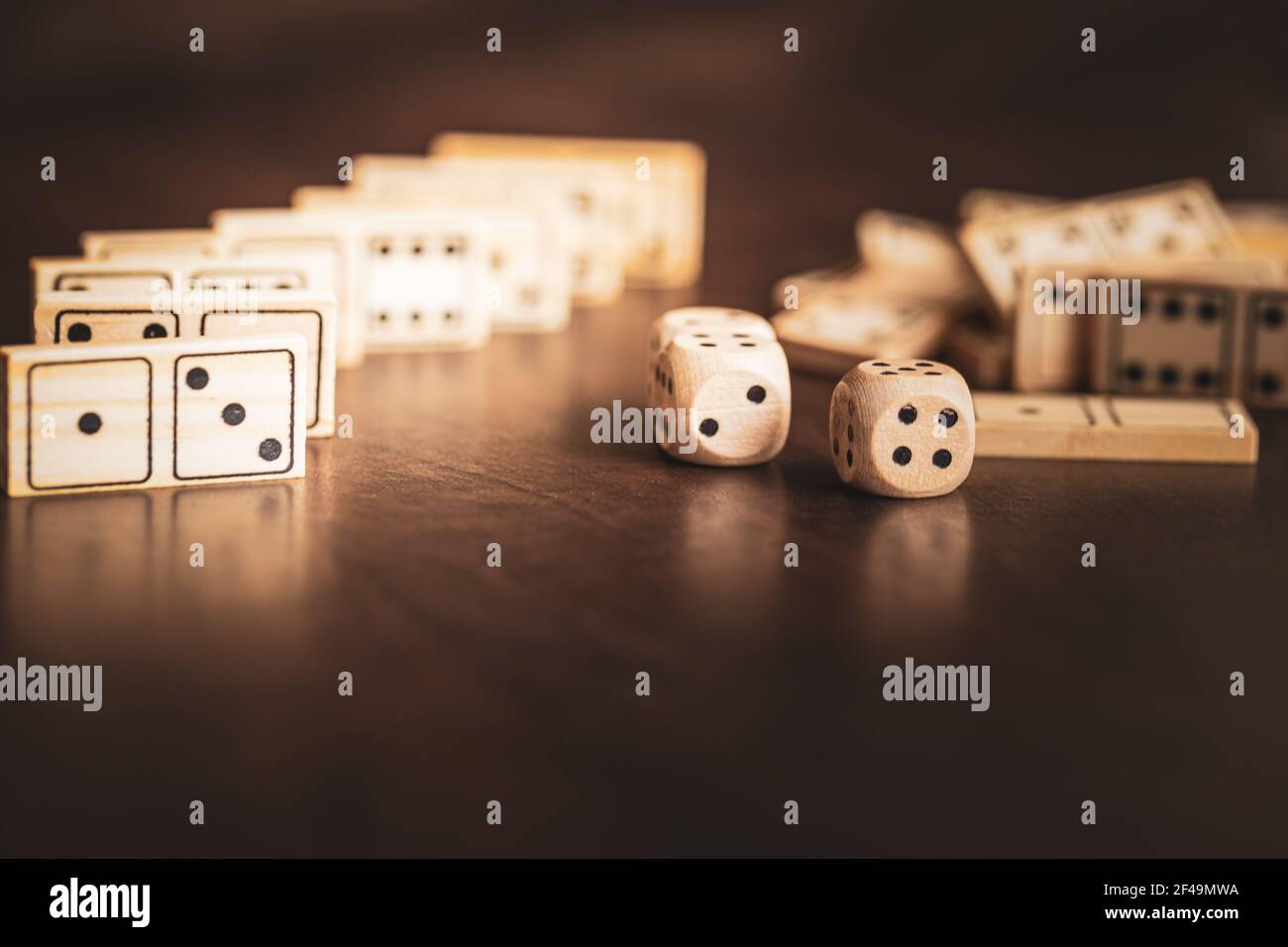 dadi e dominos, pezzi di gioco in legno su uno sfondo di legno scuro Foto Stock