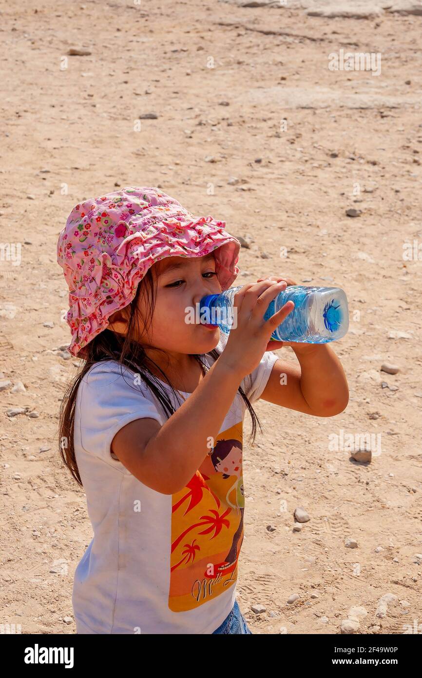 Giovane ragazza inglese-tailandese che beve da una bottiglia d'acqua dentro  il sole in un deserto Foto stock - Alamy