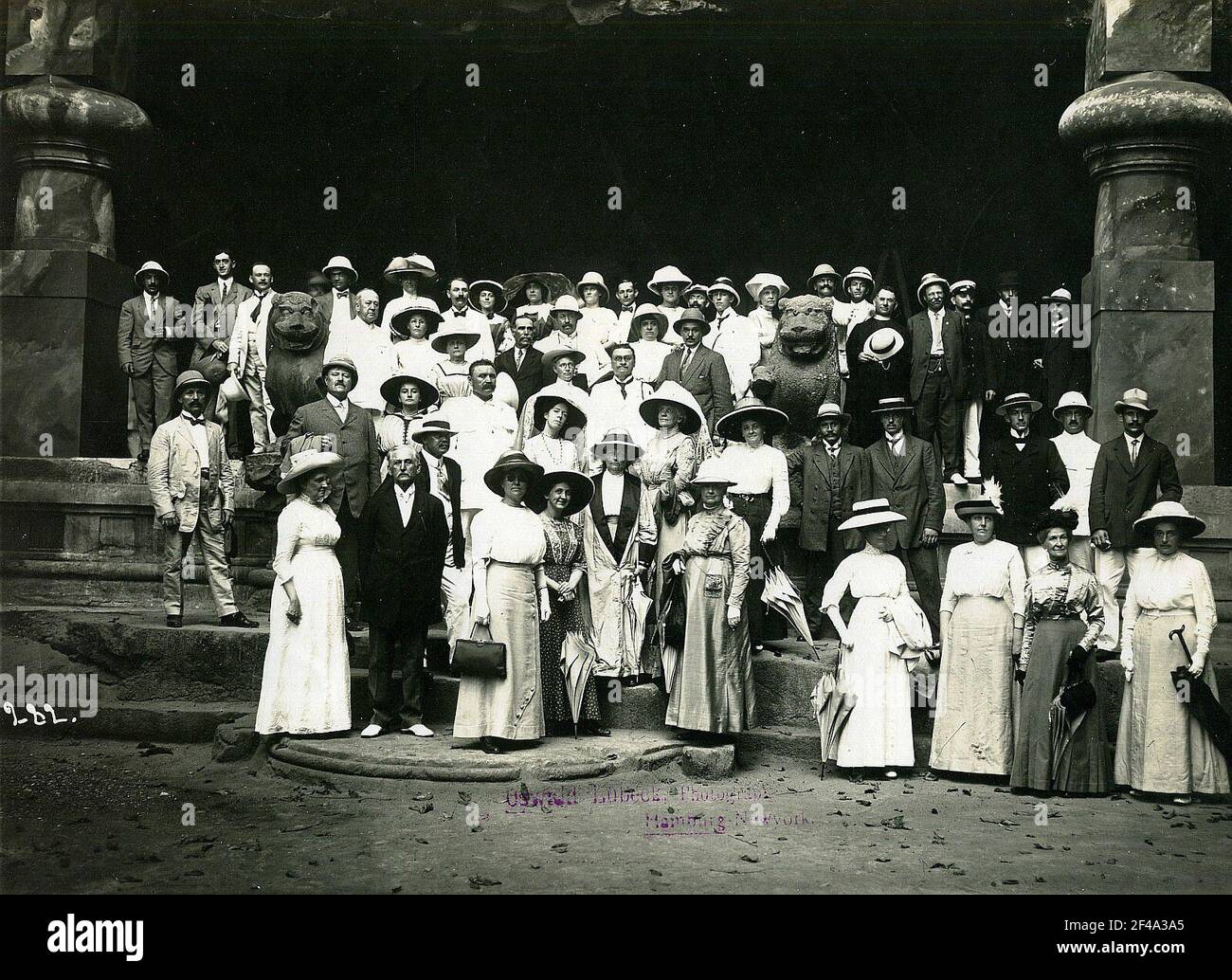 Elefanta, India. Shiva tempio di grotte di roccia. Foto di gruppo con i turisti di Hapag in uno degli ingressi con scale all'aperto e sculture di leoni fiancheggianti Foto Stock