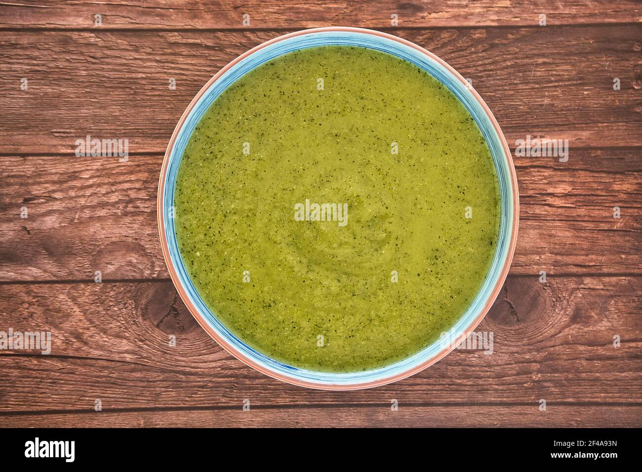 Zuppa di disintossicazione vegetale fresca a base di piselli in un piatto su un tavolo di legno marrone, vista dall'alto con spazio per il testo. Gustoso Foto Stock