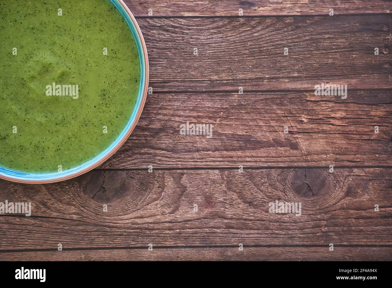 Zuppa di disintossicazione vegetale fresca a base di piselli in un piatto su un tavolo di legno marrone, vista dall'alto con spazio per il testo. Gustoso Foto Stock