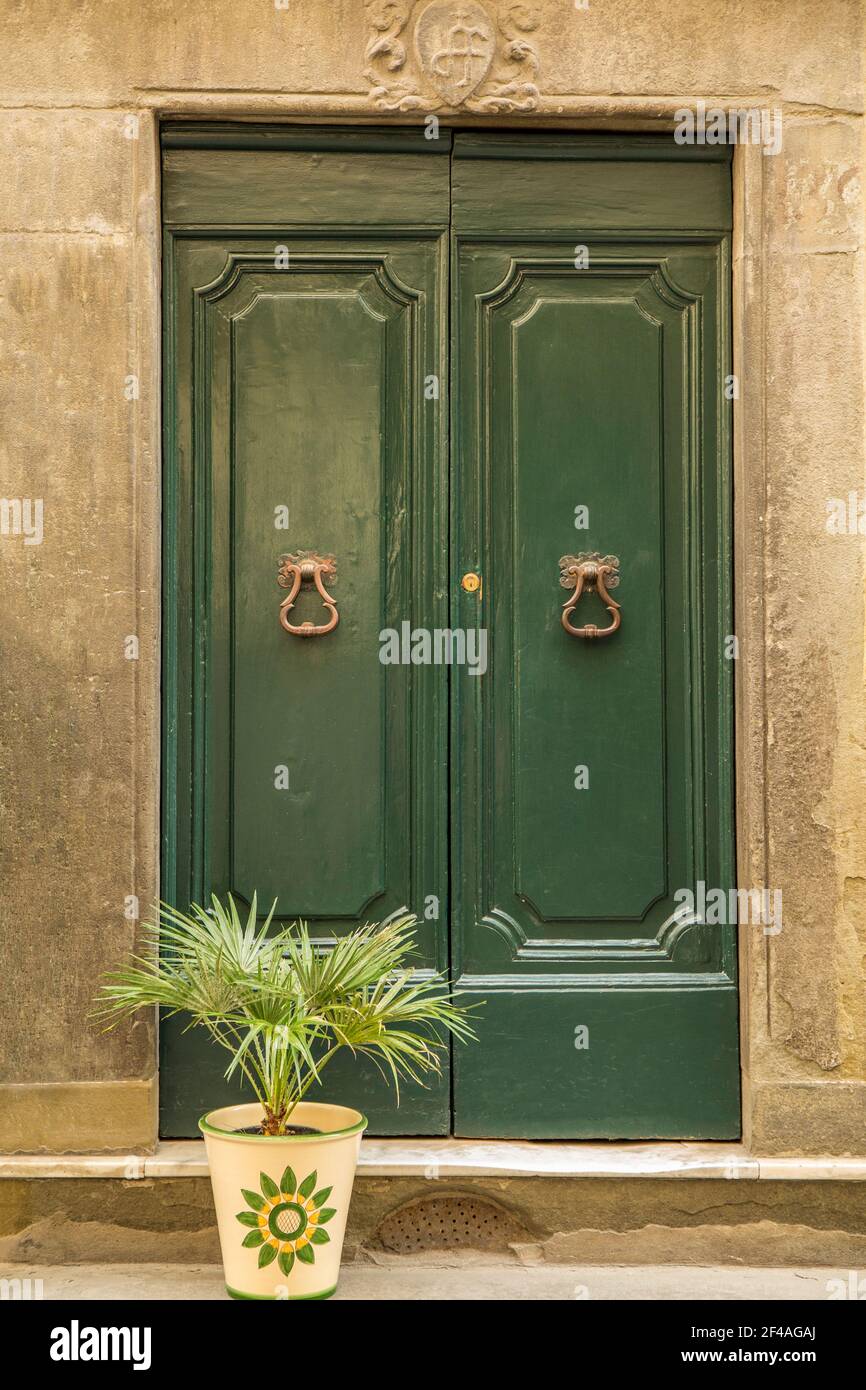 Cortona, Toscana, Italia. Porta decorativa in legno in una casa di pietra. (Solo per uso editoriale) Foto Stock