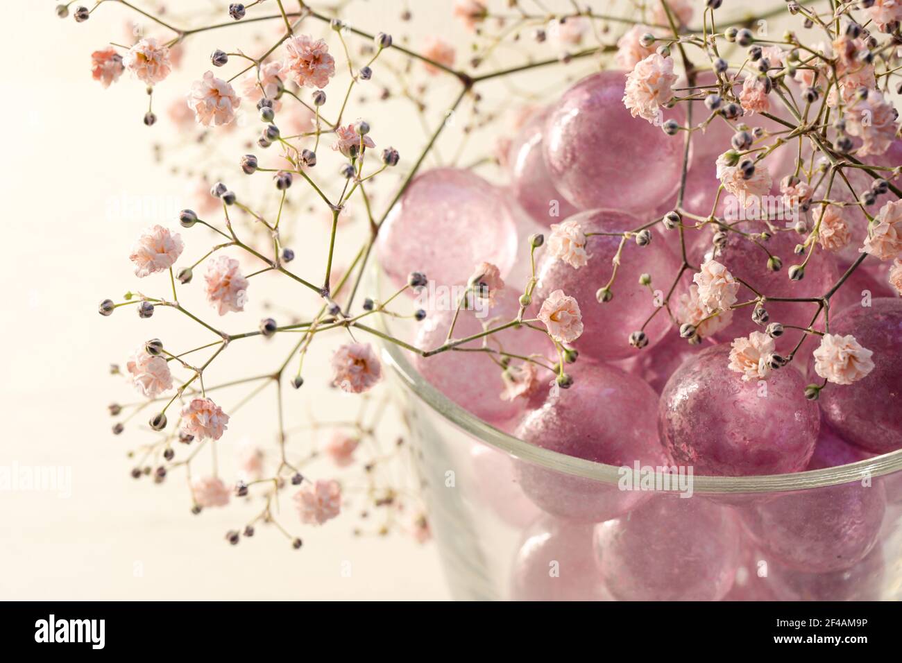 marmi di vetro rosa e fiori di gypsophila blush come decorazione femminile per bellezza, benessere e romantici concetti interni, spazio copia, selezionato foc Foto Stock
