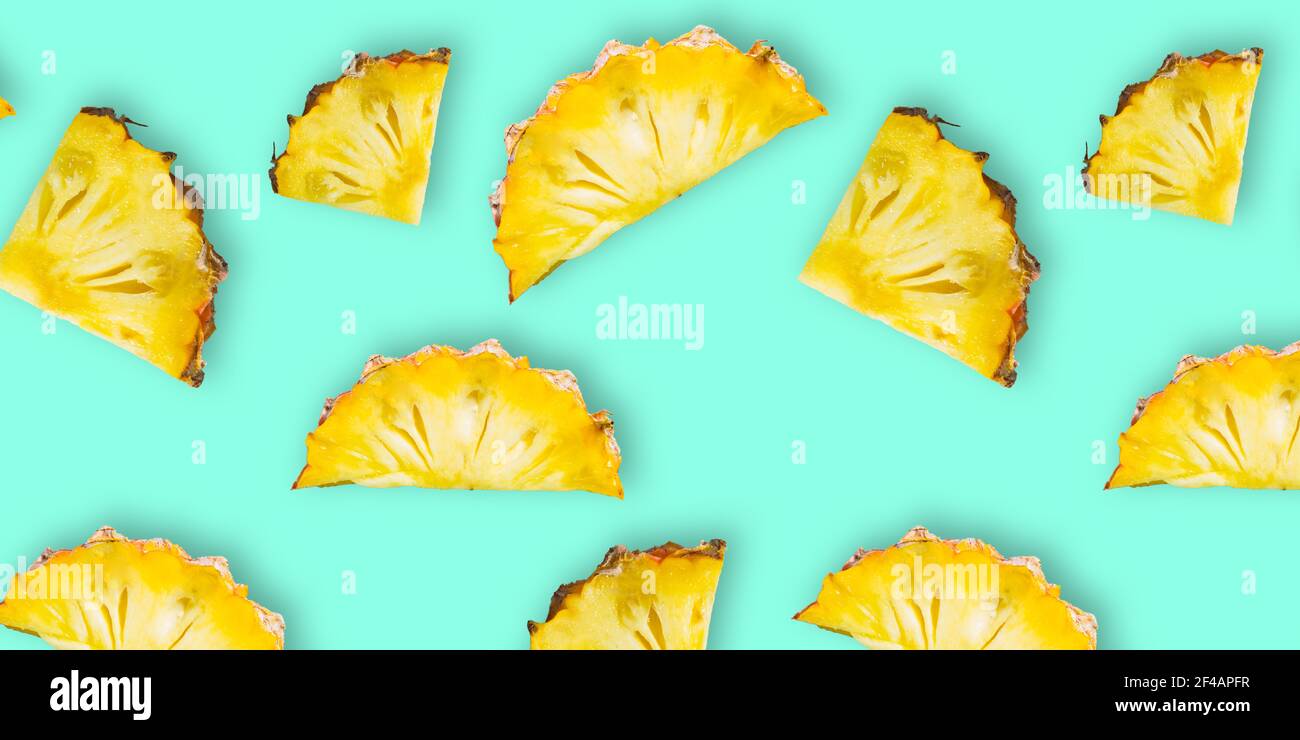 Modello di fette di ananas fresche mature isolate su sfondo ciano. Vista dall'alto Foto Stock