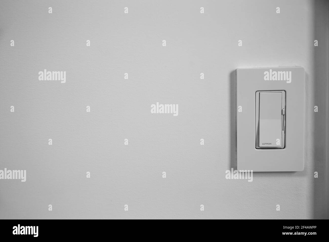 Dimmer con interruttore luminoso singolo su una parete bianca con spazio per il testo Foto Stock