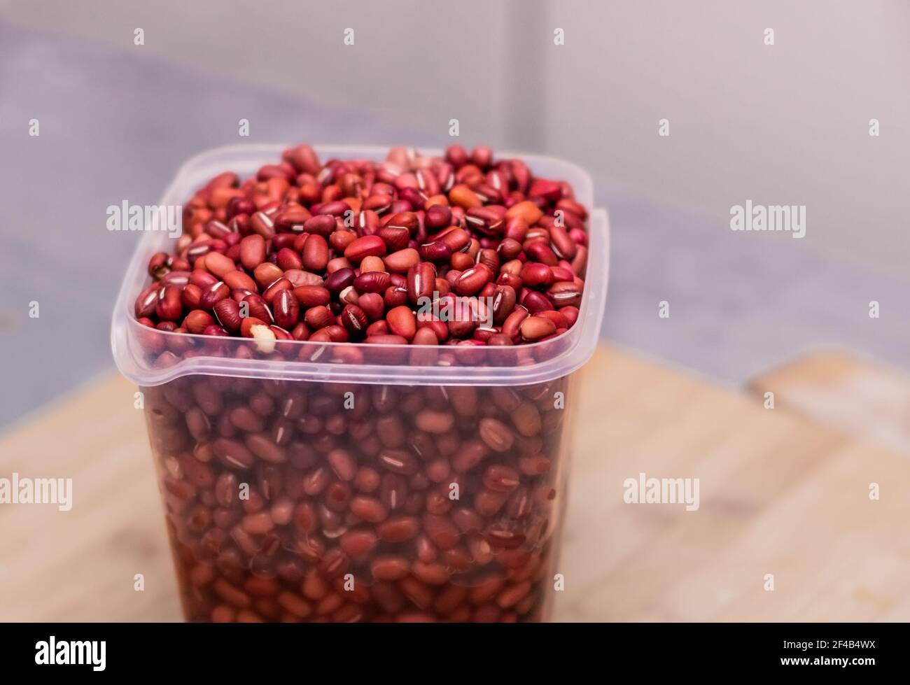 Fagioli rossi secchi imbevuti in un contenitore sul banco della cucina. Grande fonte di proteine per la cucina vegetariana o la dieta. Utilizzato in chili o zuppe Foto Stock