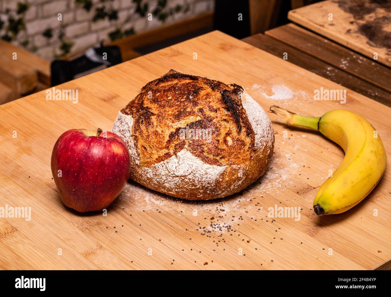 Pane di pasta fresca sfornata sul banco della cucina. Pane rustico di lievito con banco di legno di mela e banana. Pane di pasta frolla gratta. S Foto Stock
