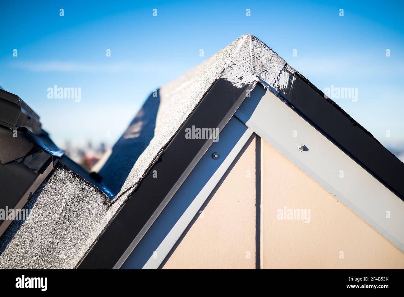 Angolo tetto apribile con riparazione impermeabilizzante su metallo lampeggiante. Manutenzione del tetto su lucernario con un sistema di copertura a 2 veli SBS o bitume modificato e. Foto Stock