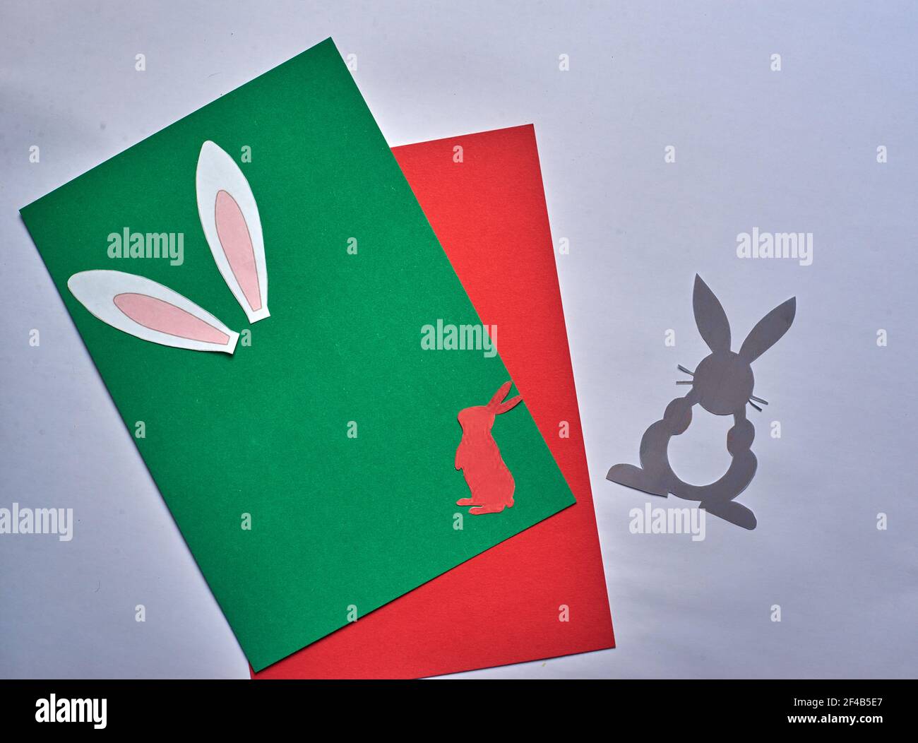 orecchie di pasqua coniglietto su sfondo verde e rosso Foto Stock