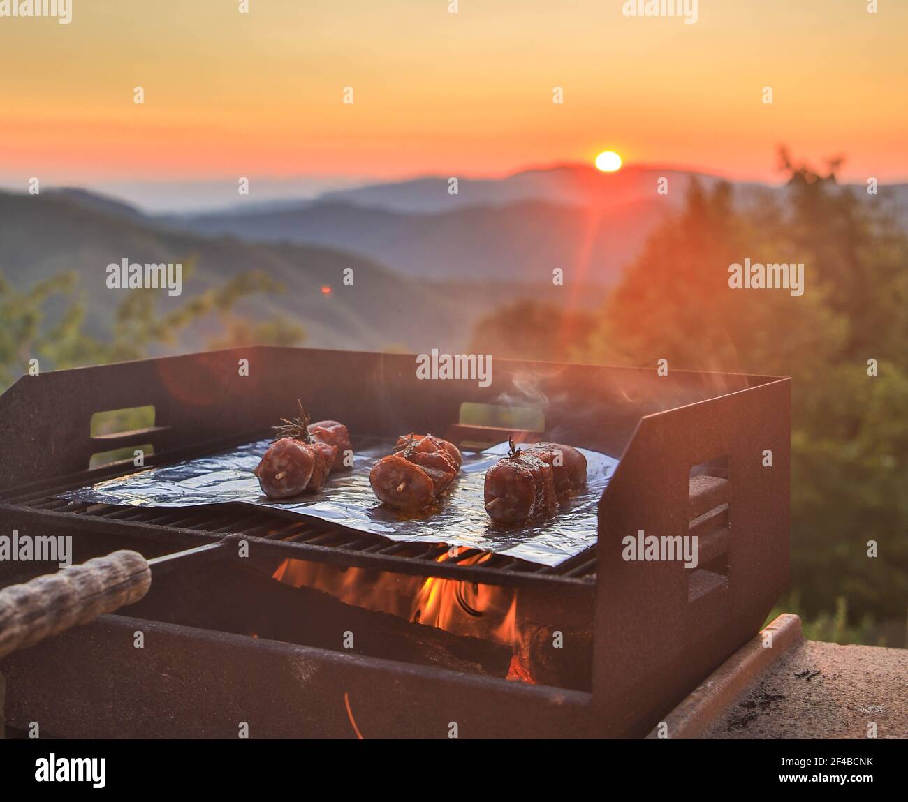 Bistecche di manzo su una griglia con bellissimo tramonto. Toscana, Italia Foto Stock